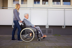elderly woman in wheelchair with caregiver