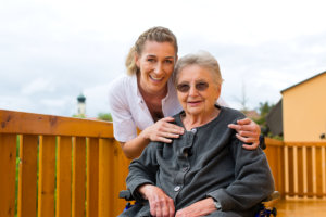 elderly woman in a wheelchair with caregiver